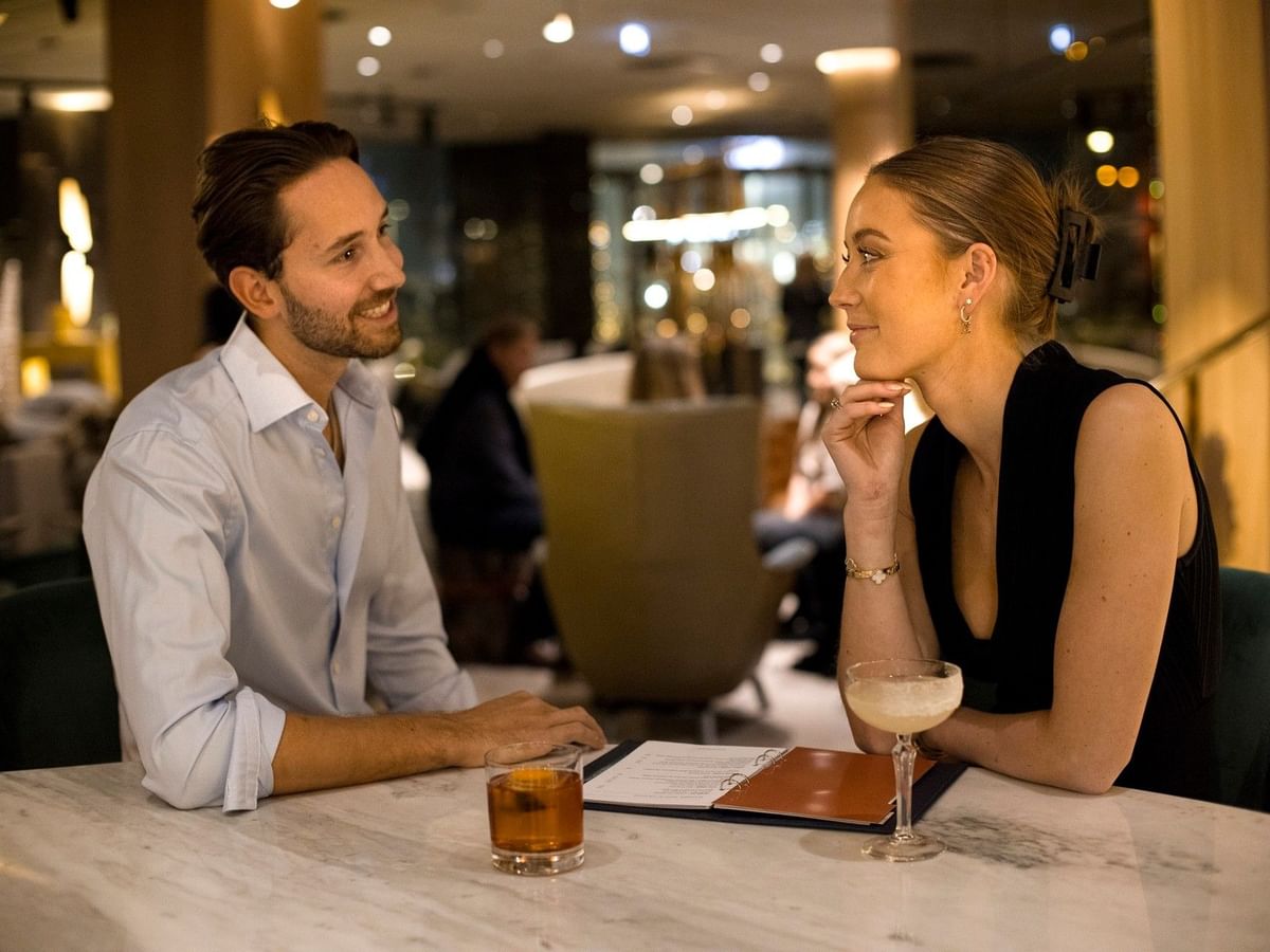 Couple enjoying cocktails in the restaurant during a luxury staycation at Hotel Riverton Gothenburg