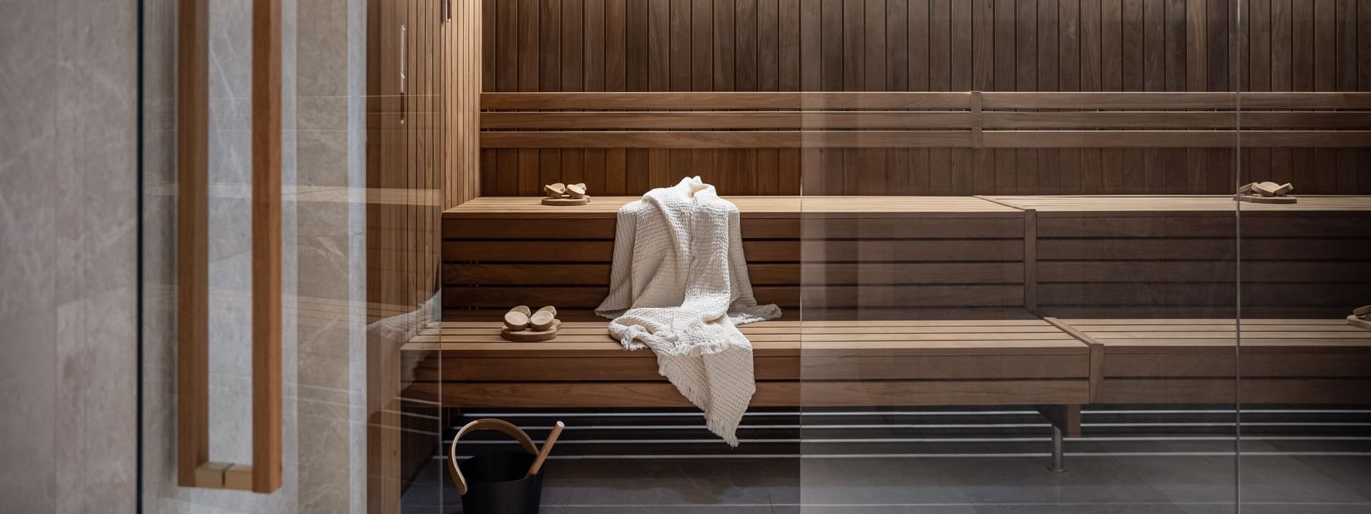 Sauna room with wooden benches, robe and slippers Almanac Palais Vienna