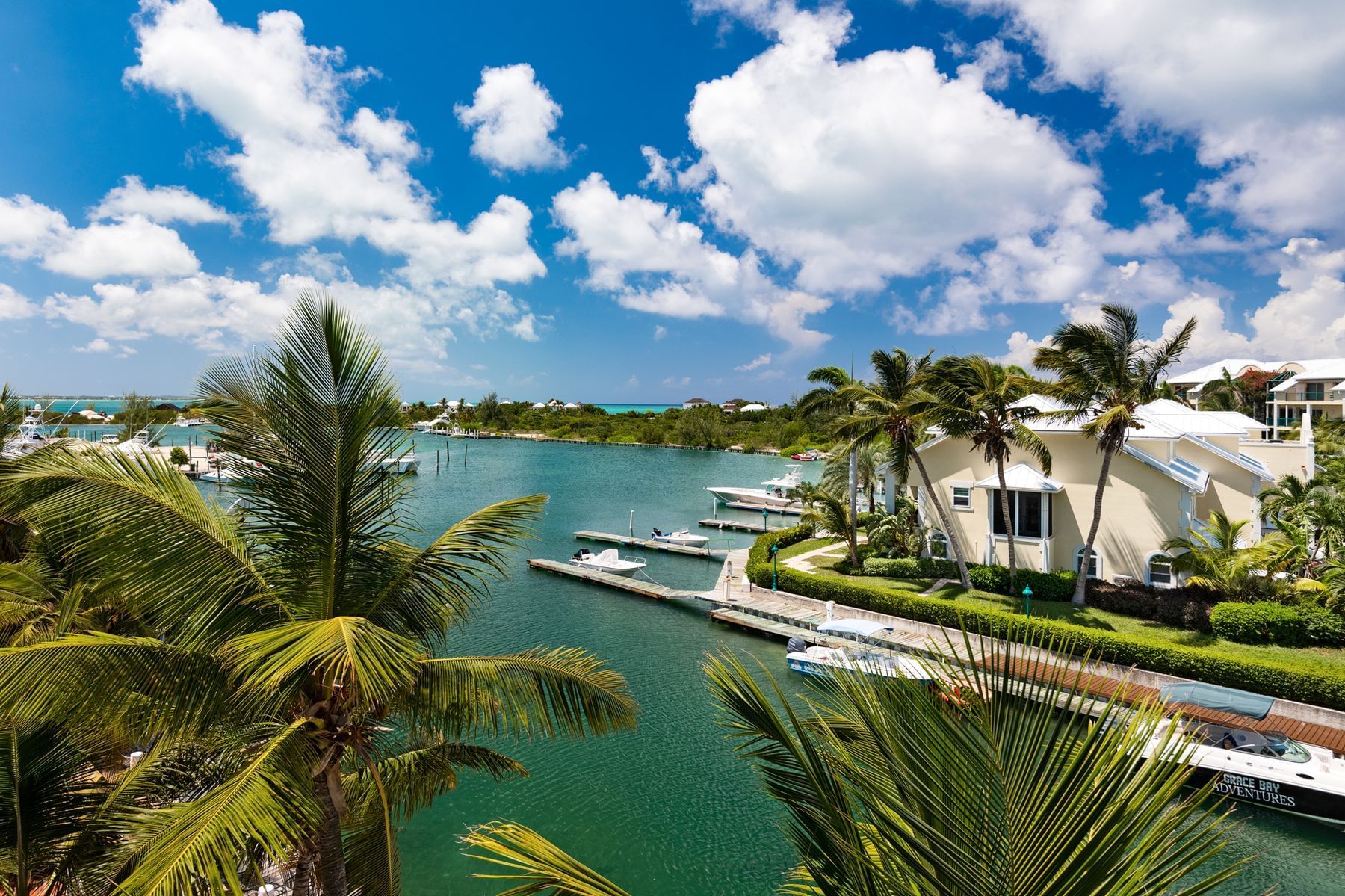 Lush gardens and white villas beside the canal at Zenza Hotel a boutique waterfront hotel in Turtle Cove Turks and Caicos