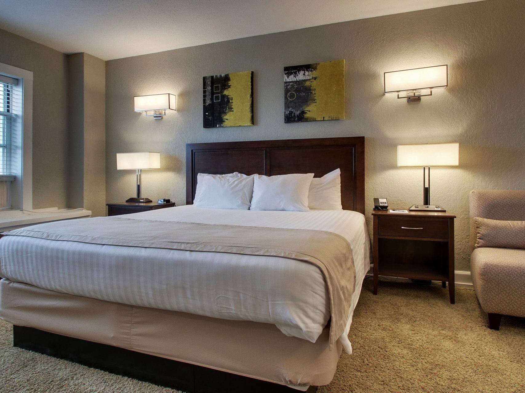 Lounger & nightstands by the bed in Standard Room at Knickerbocker On The Lake, featuring stylish accommodations in Milwaukee