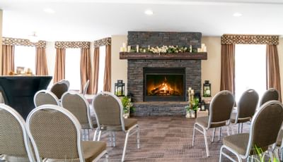 Event space with chairs facing a decorated fireplace at or near Falcon Crest Lodge