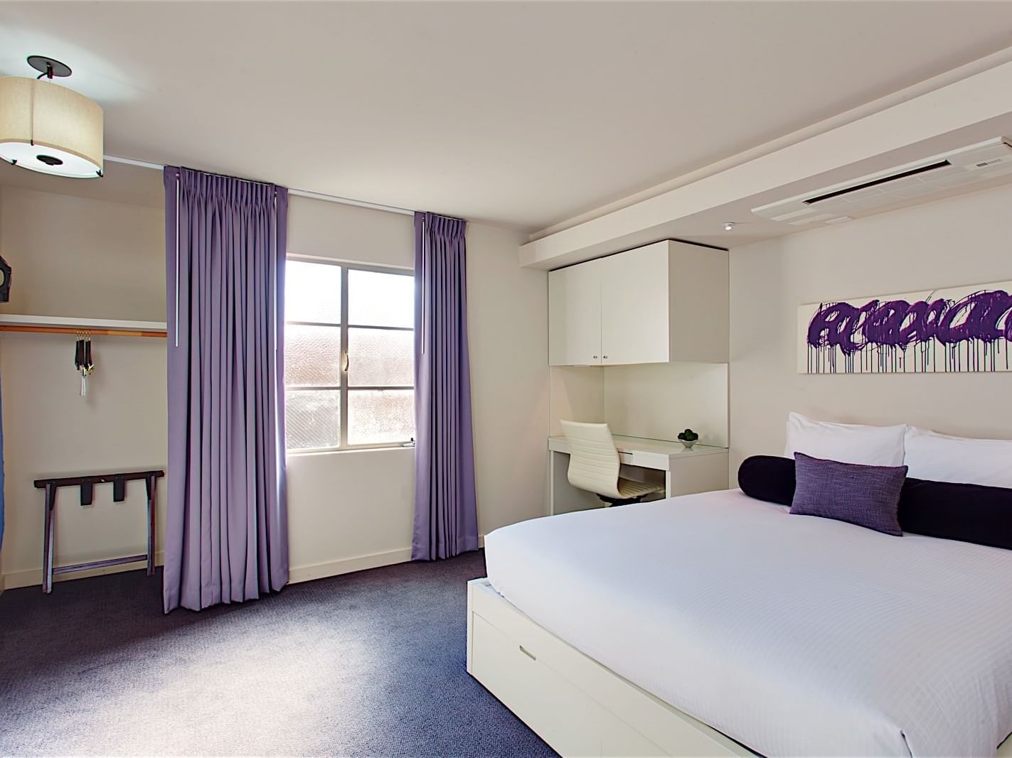 hotel keen guest room with desk, closet and bed