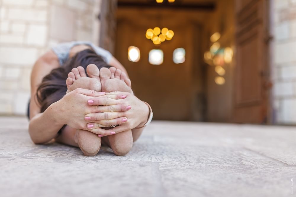Woman stretching on the ground for Allegretto Yoga