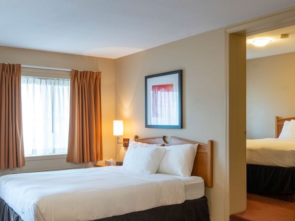 queen bed in a private bedroom in our Coast Two Queens Pet Friendly room