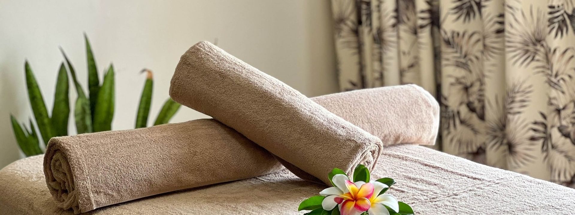 Towels and tropical flowers on spa bed at The Joy Spa, The Naviti Resort - Fiji, Korolevu