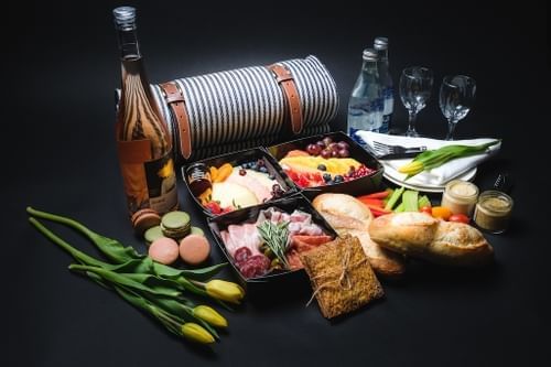 Pique-nique gastronomique avec vin, fromage, fruits, charcuterie, pain et tulipes sur une surface à l'hôtel X de Toronto