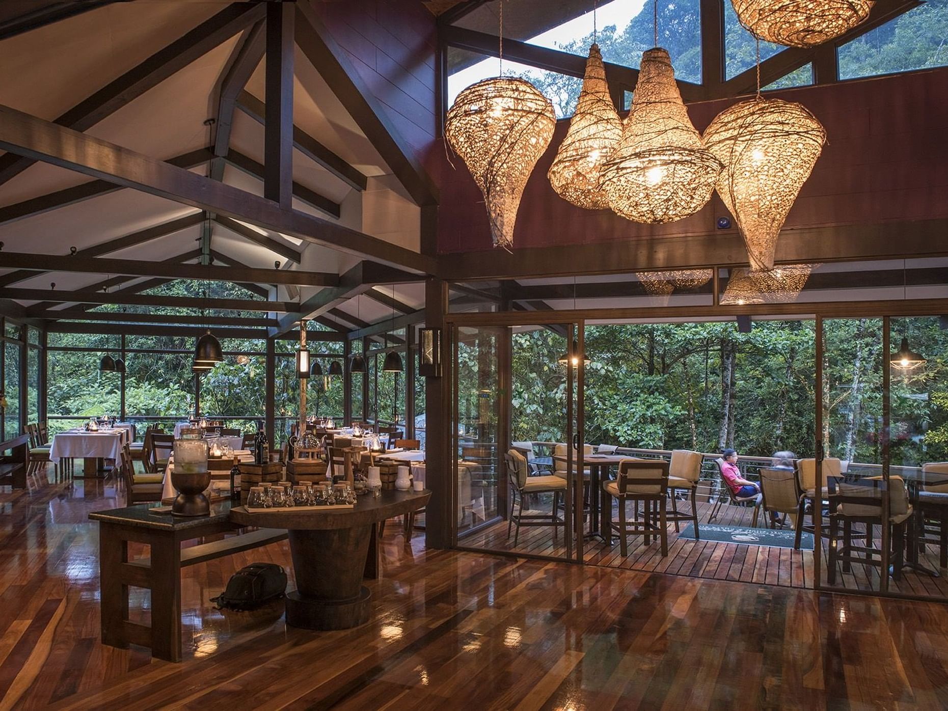 Dining area with set up tables and forest view in Las Ventanas Restaurant at El Silencio Lodge and Spa