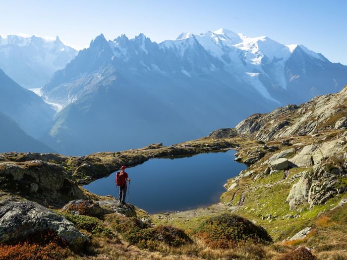 Long shot of a hiker standing by a tarn near Originals Hotels