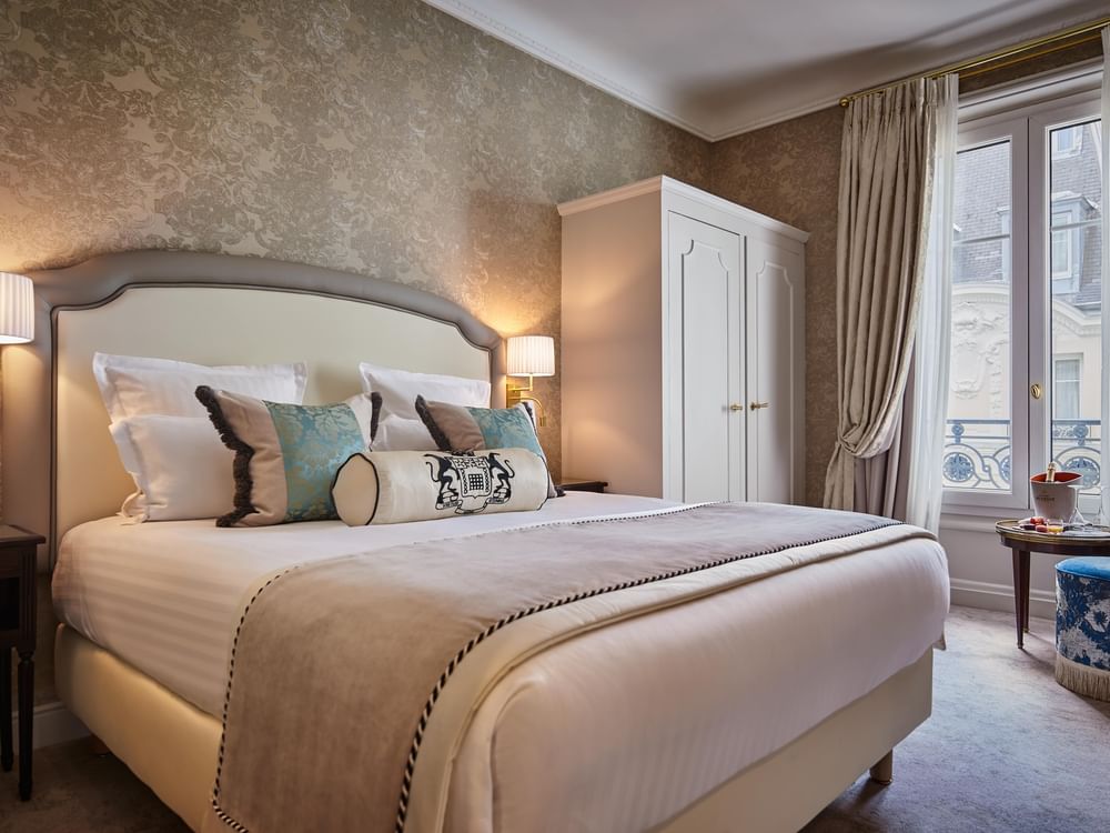 Bed with white cupboard near window in Executive Room at Hotel Westminster Paris