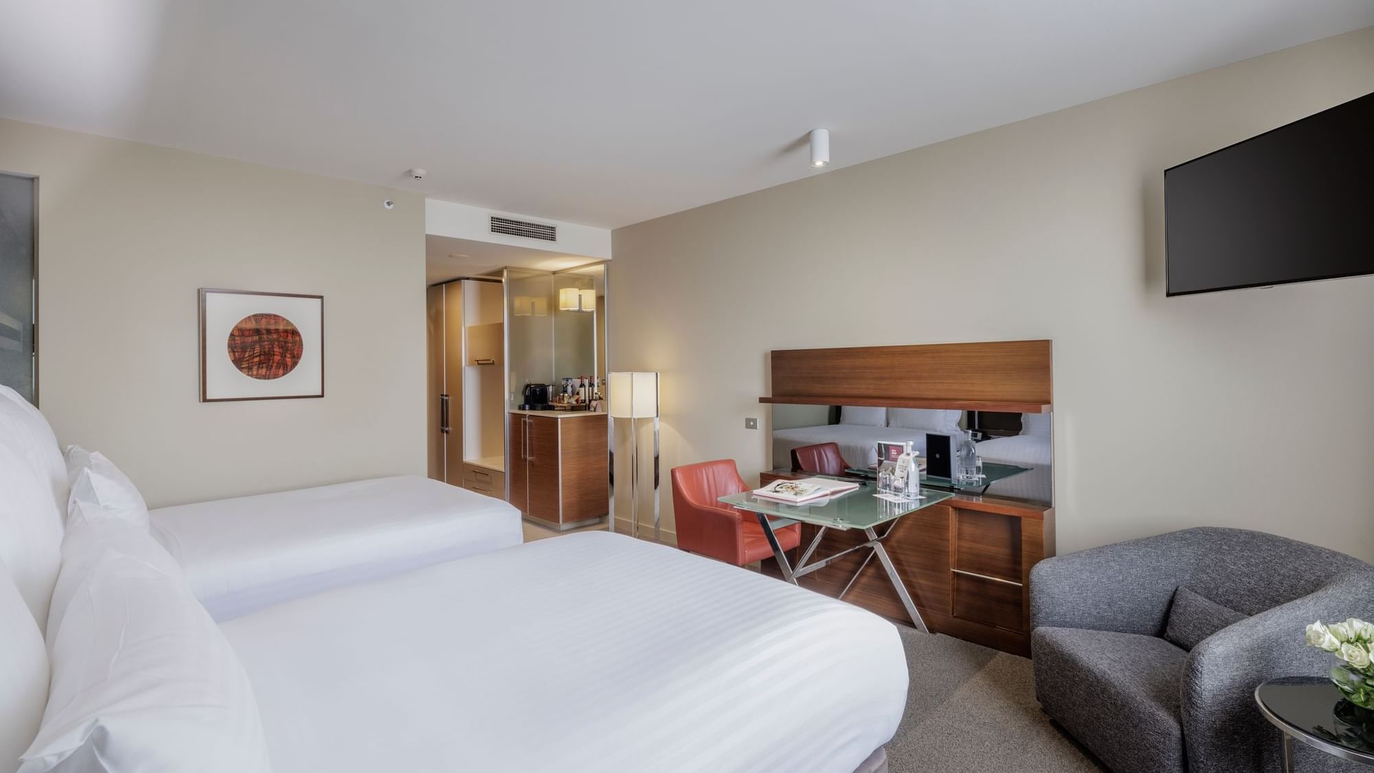 Wall-mounted TV with work desk facing two beds in Deluxe Room - Two Double bed at Pullman Sydney Olympic Park