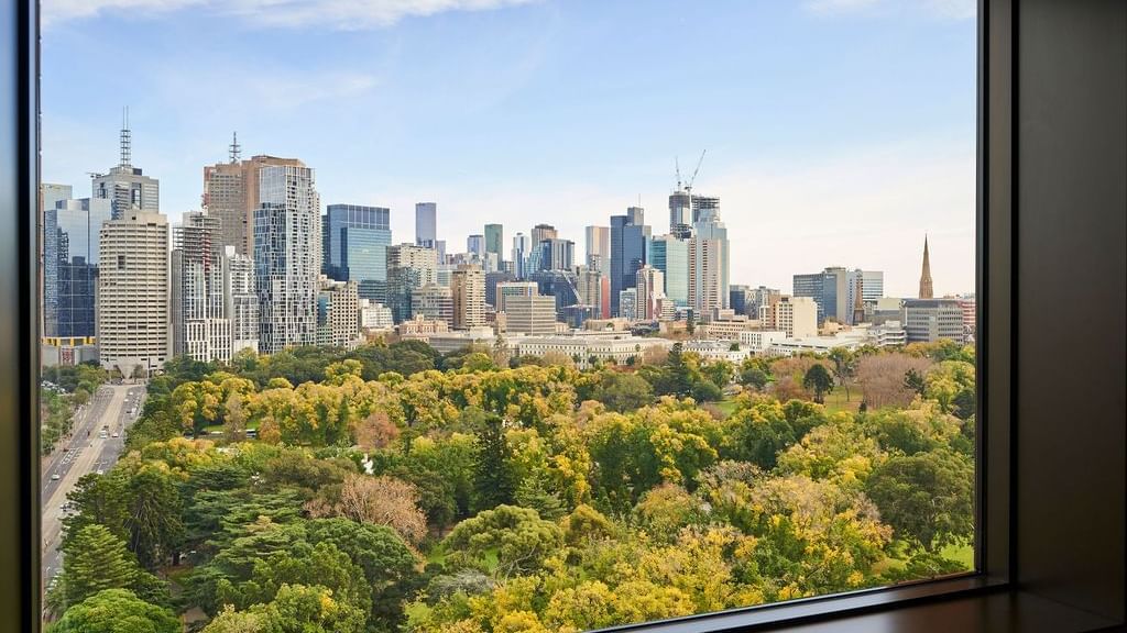 Deluxe Executive Suite window view overlooking parkland and city skyline at Pullman East Melbourne