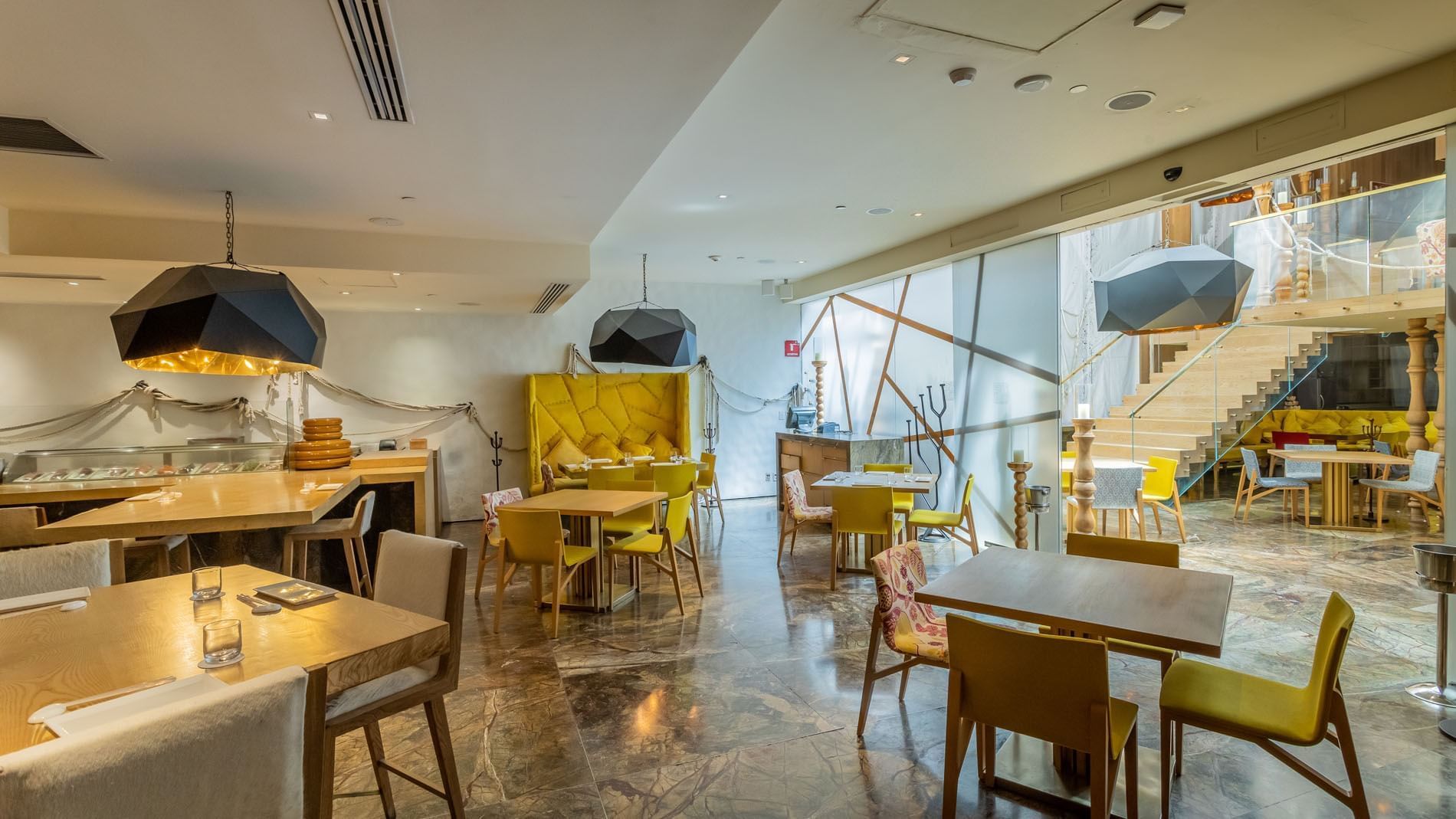Morimoto restaurant with yellow chairs, marble floors, and art lamps at Camino Real Polanco Mexico