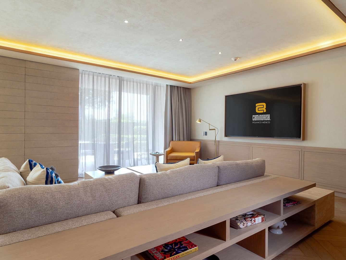 King Superior Viceroys Suite living room with a TV, tan sofa, and neutral wall paneling at Camino Real Polanco Mexico