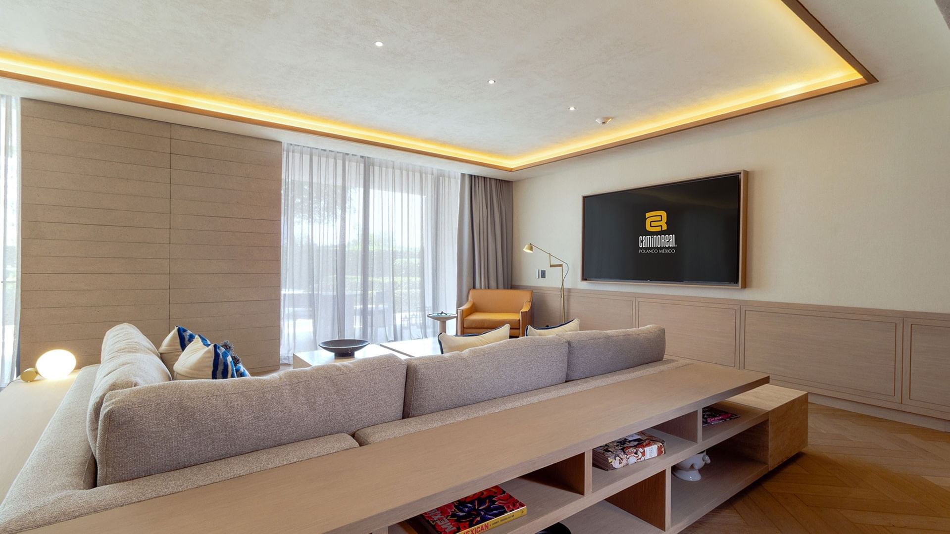 King Superior Viceroys Suite living room with a TV, tan sofa, and neutral wall paneling at Camino Real Polanco Mexico