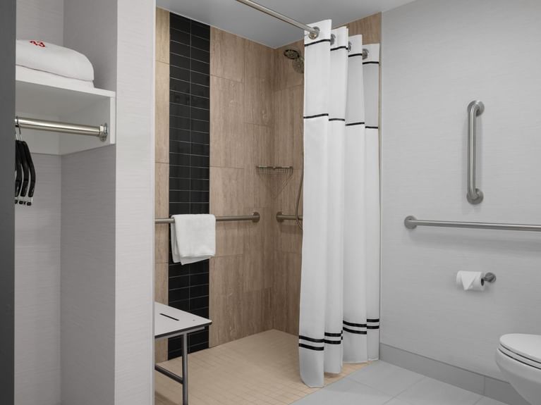 Boutique King Accessible bathroom with a walk-in shower, grab bars, and a fold-down seat for guest comfort at Hotel 43 Boise