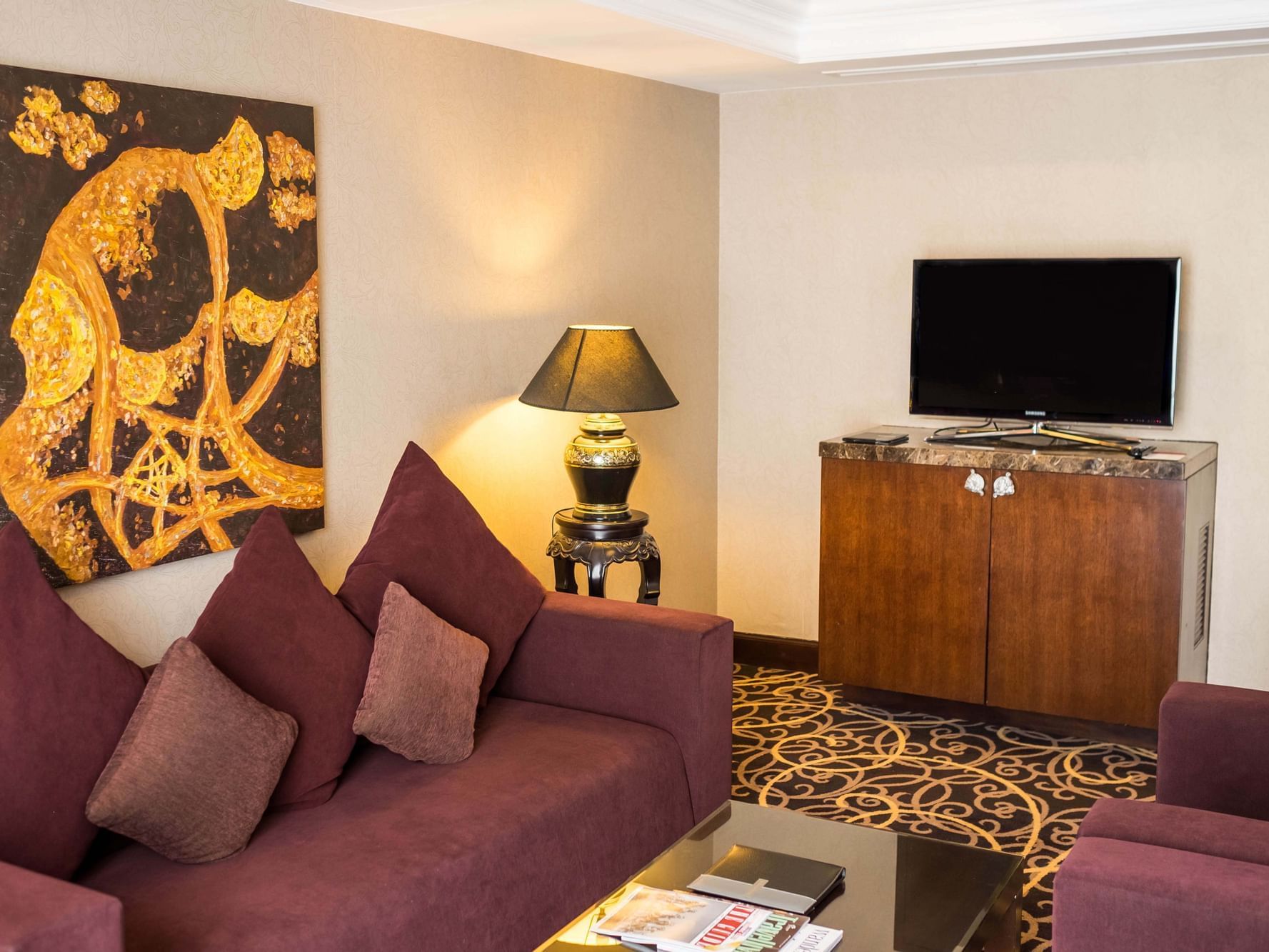 TV & a comfy sofa set in Club Grand Executive Suite's living room at Eastin Grand Hotel Saigon