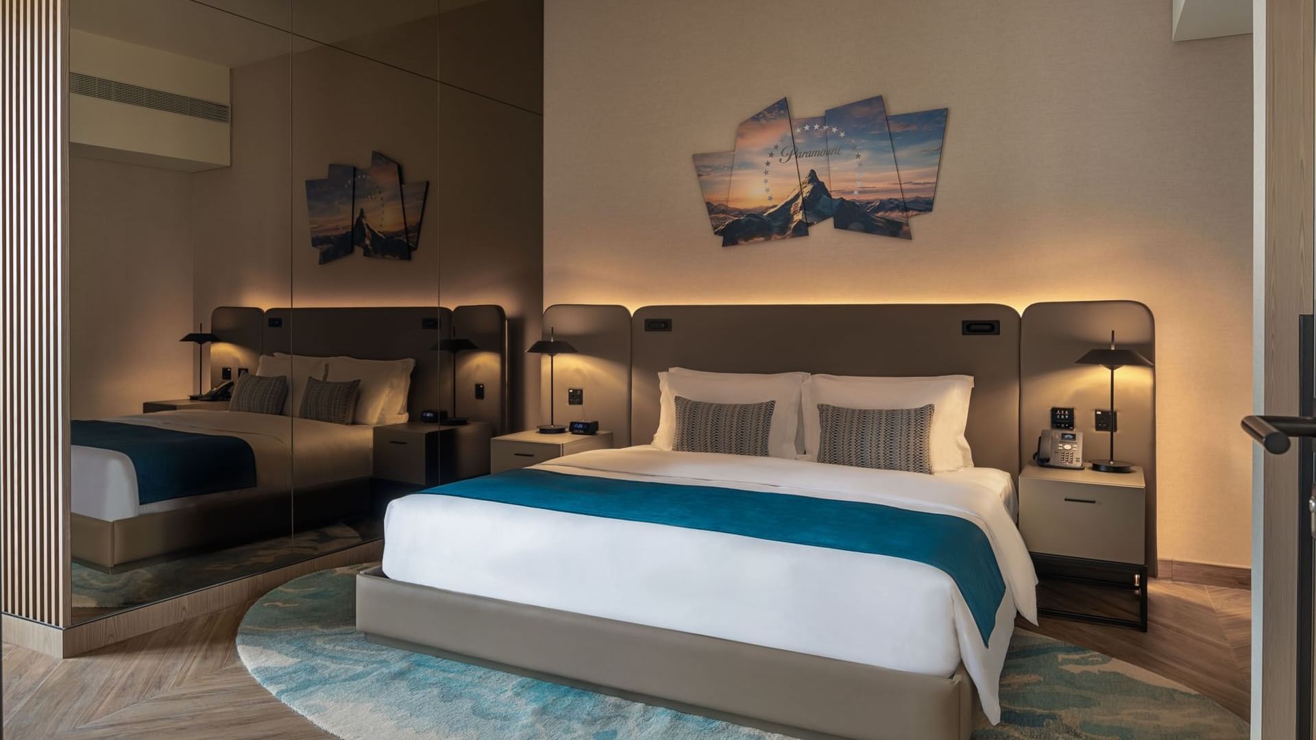 Comfortable hotel bedroom with a king-size bed, mirrored wall, and stylish rug at Paramount Hotel Midtown