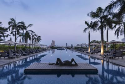 Floating deck with a sculpture in the pool at Chatrium Hotel