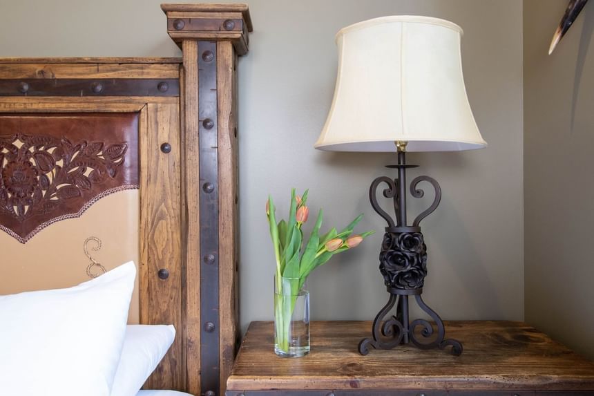Lamp & fresh flowers on the bedside cupboard in King Premiere Wild Wild West at Retro Suites Hotel