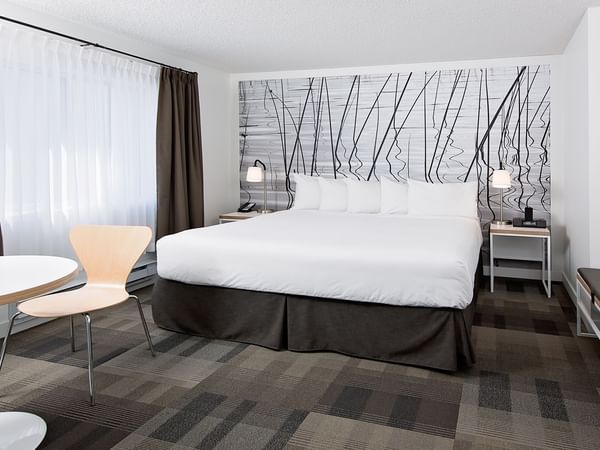 Bed in hotel room with modern artwork