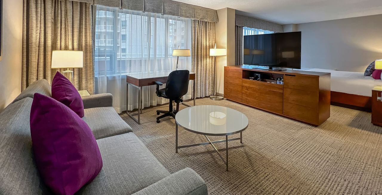 Hotel room with TV, bed, working desk, and sofa