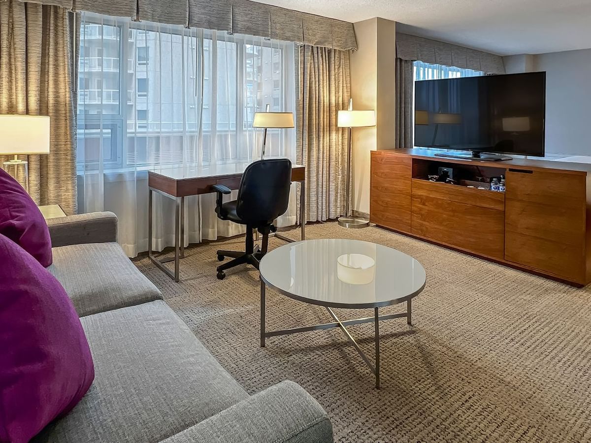 Sofa, desk, TV, bed, table in a hotel room