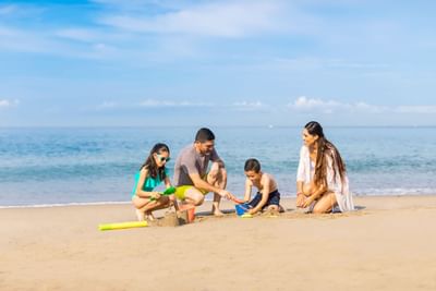 Family playing with sand on beach at Buenaventura Grand Hotel