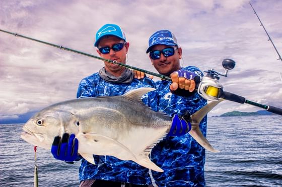 Close-up of men holding a fish caught from the sea near Jungle Vista Boutique Hotel