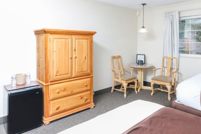 Room with two beds, dresser and a table at Alpenhof Lodge