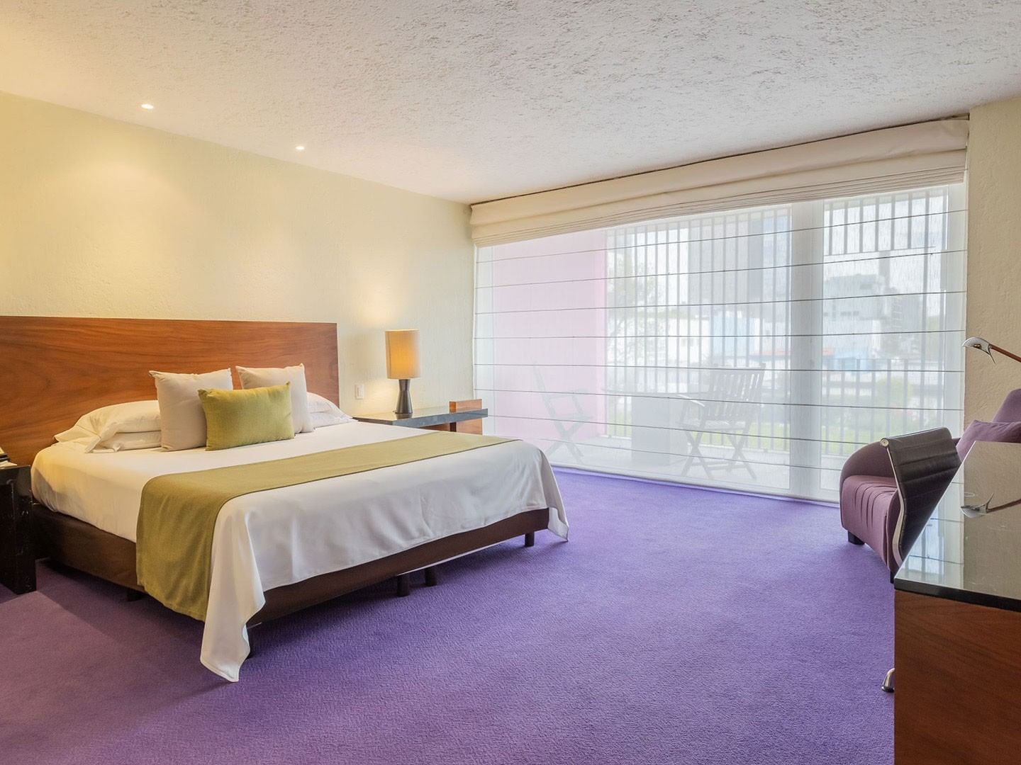 King Viceroys Suite featuring a king bed, purple carpet, and a large sunlit balcony window at Camino Real Polanco Mexico