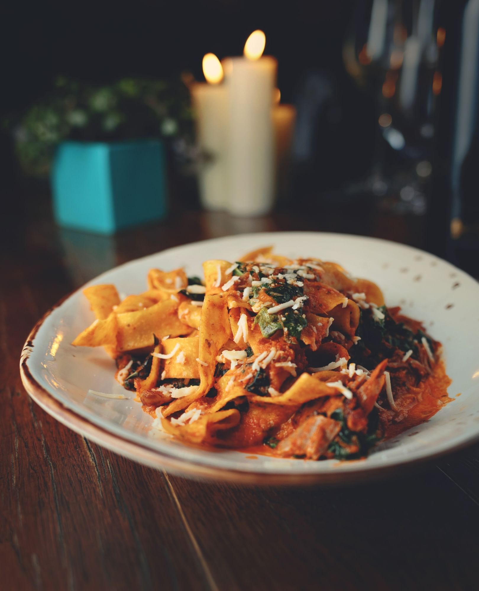 Lorem ipsum A plate of thick flat pasta noodes with red sauce and parmesan cheese