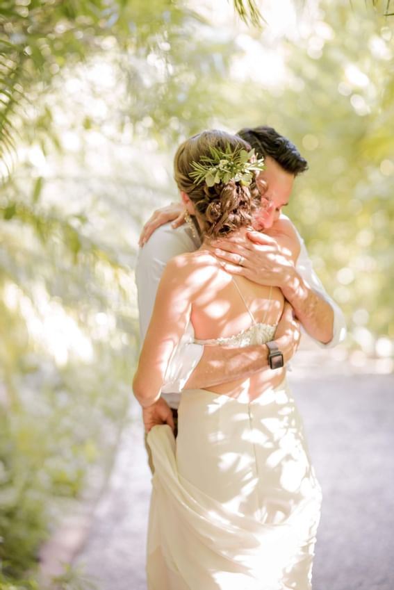 A wedded couple hugging each other at Cala Luna Boutique Hotel