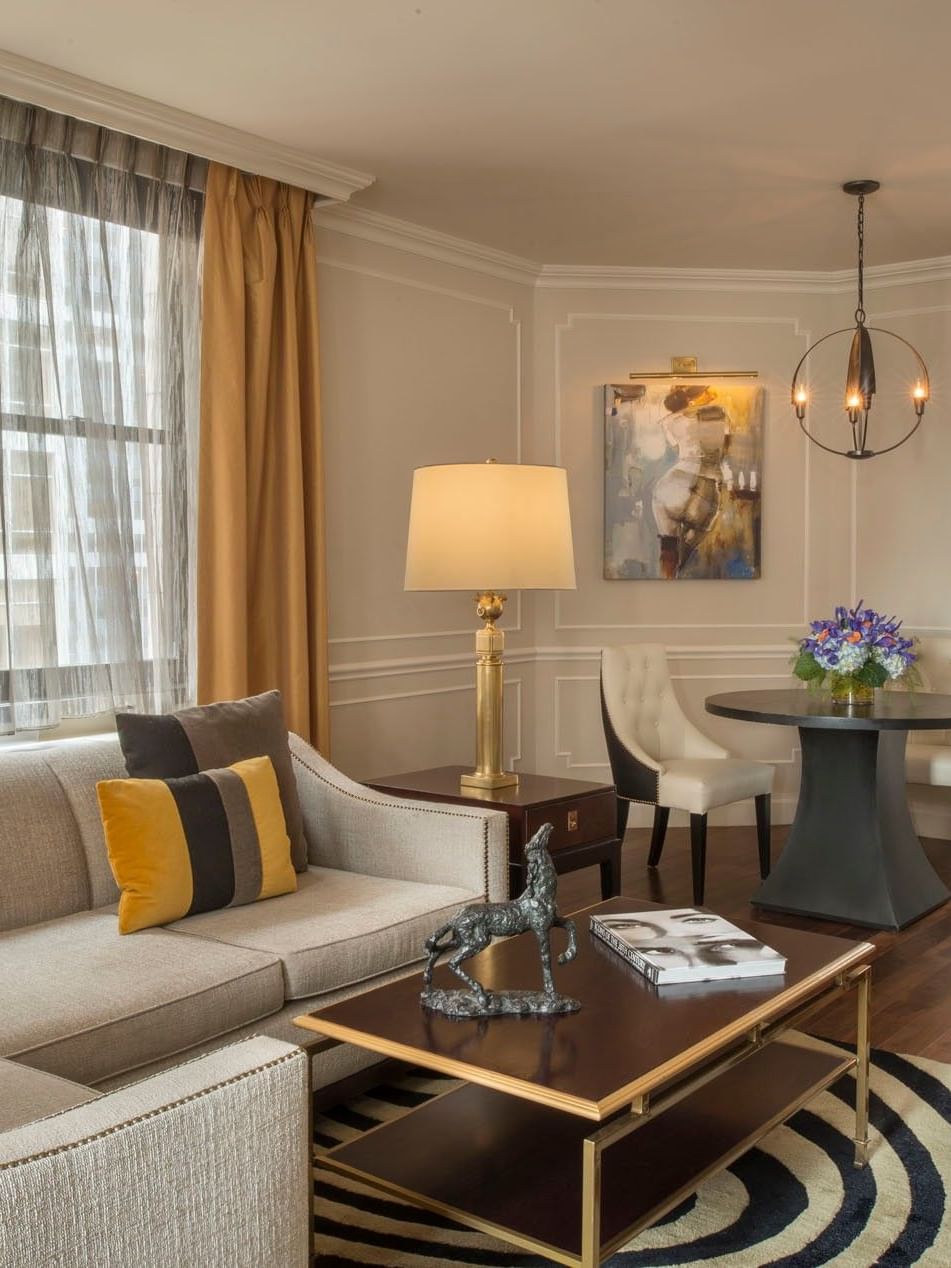 Chic living space with a tan sectional sofa with table and beside dining area beside in Jane Suite at Warwick New York