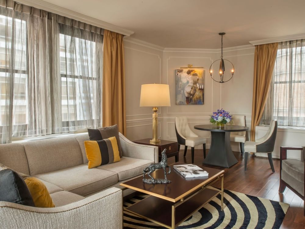 Chic living space with a tan sectional sofa with table and beside dining area beside in Jane Suite at Warwick New York