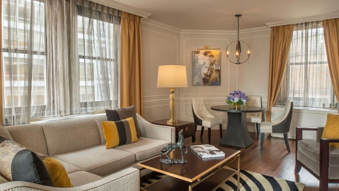 Chic living space with a tan sectional sofa with table and beside dining area beside in Jane Suite at Warwick New York