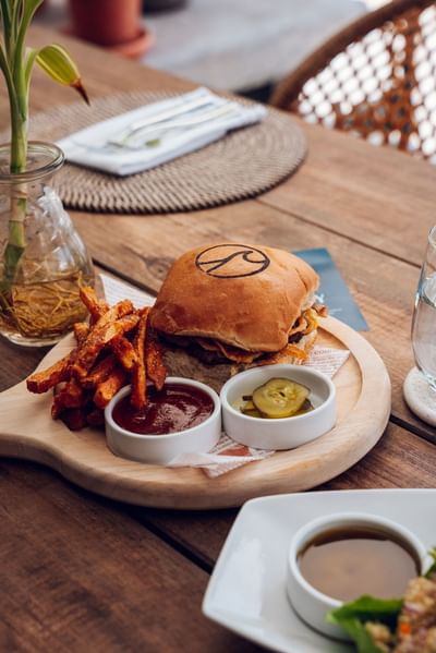 Burger with fries, served in Azure Restaurant & Bar, among best restaurants in Roatan at Barefoot Cay Resort & Marina