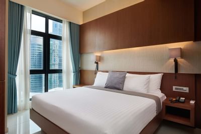 Queen bed by the window in Duo Suite at Tribeca Serviced Suites
