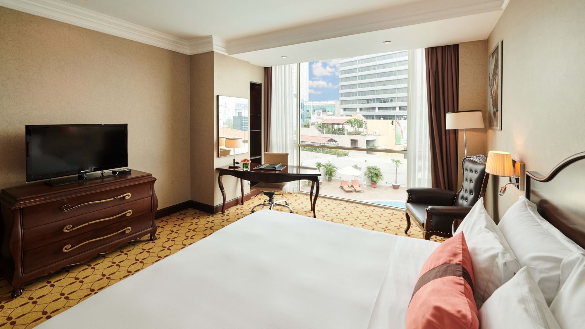 Bed & furniture in Deluxe Room with city view at Eastin Hotels