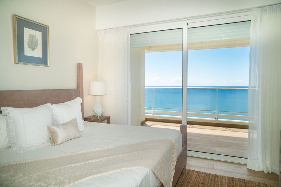 Comfy bed in a room with sea view balcony at Club Hemingway