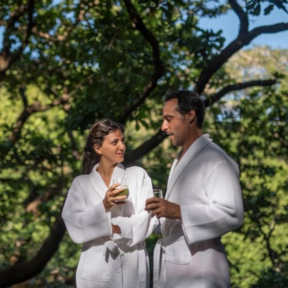 Couple sipping on drinks wearing bathrobes at Hotel Rio Perdido