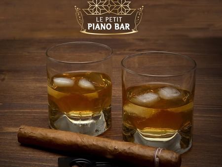 Whiskey glasses with a cigar served on a table in Le Petit Piano Bar at Warwick Palm Beach Hotel - Beirut