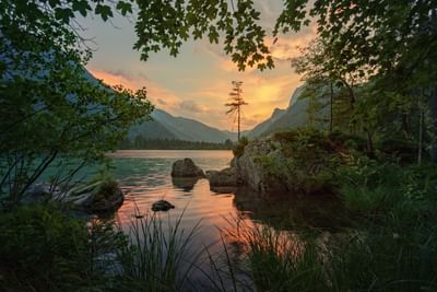 Sunset over Calm Lake with silhouettes of trees and mountains near The Lodge at Schroon Lake