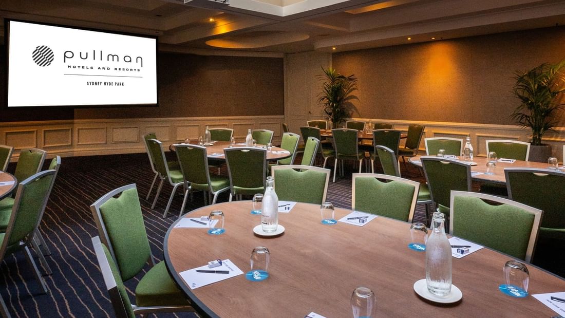 Banquet set-up with projector screen in Ibis Room at Pullman Sydney Hyde Park