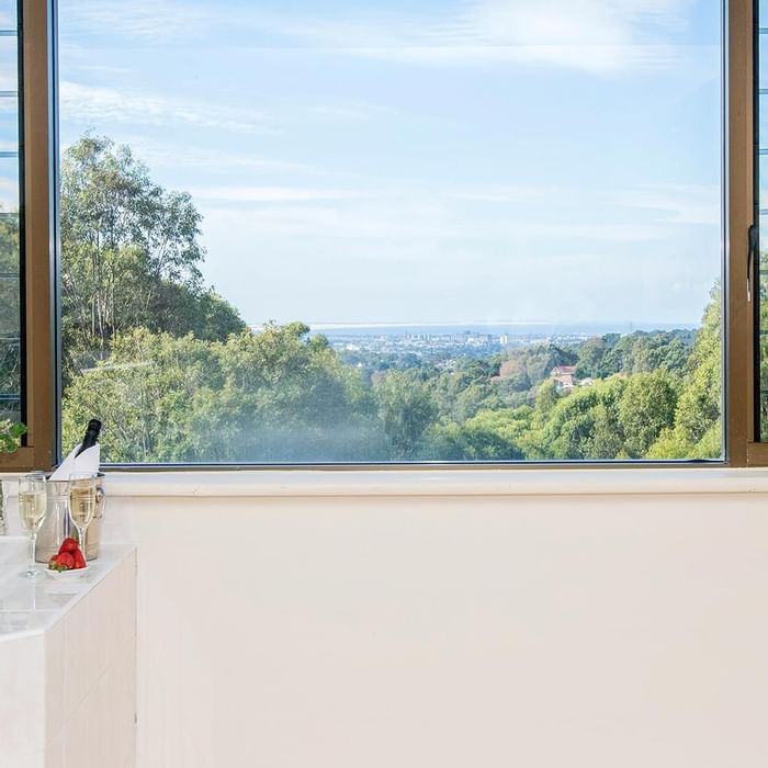 Champagne, rose & strawberries by the bathtub with a distant city view in Privilege King Spa room at Mercure Charlestown