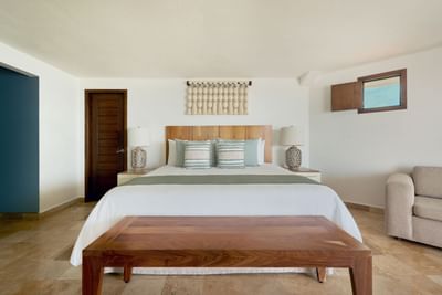 Interior of a hotel room with a bed, nightstands, and a couch.