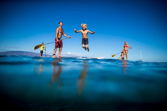 Boy jumping off paddleboard at Ka'anapali Beach Hotel Hawaii