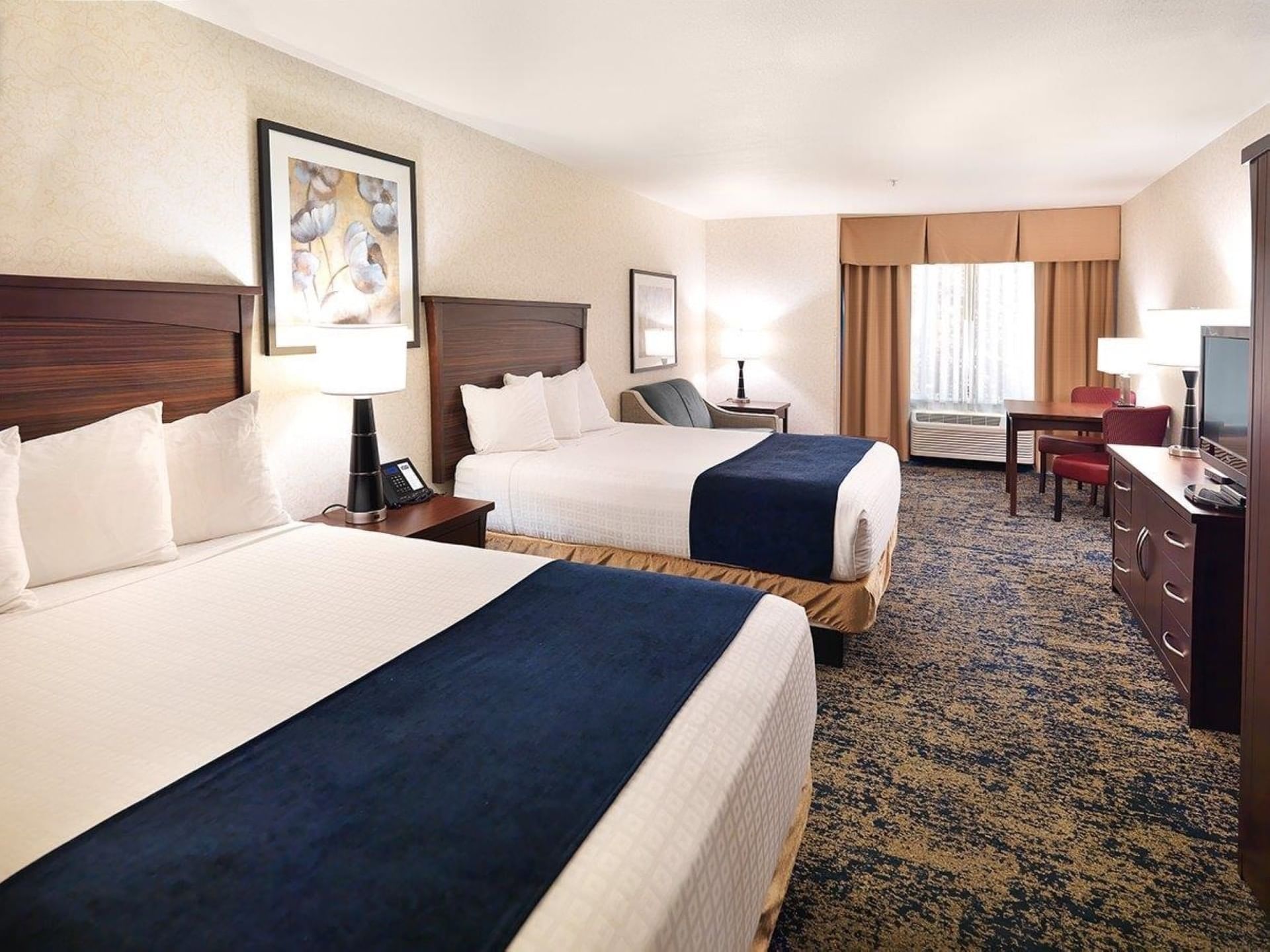 Beds and working area in Double Queen Room with carpeted floors at Crystal Inn Salt Lake City