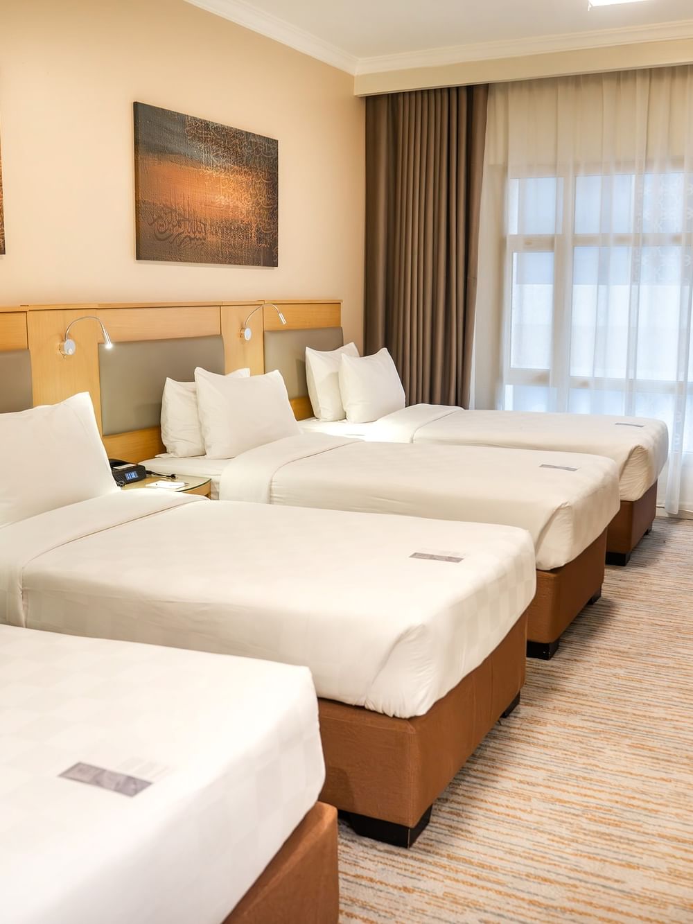 غرفة خماسية قياسية مزودة بأربعة أسرّة وأثاث وأعمال فنية في فندق سجى ورويك المدينة المنورة.