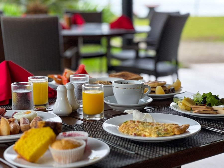 Plates of breakfast food and drinks on a table at The Naviti Resort Fiji.