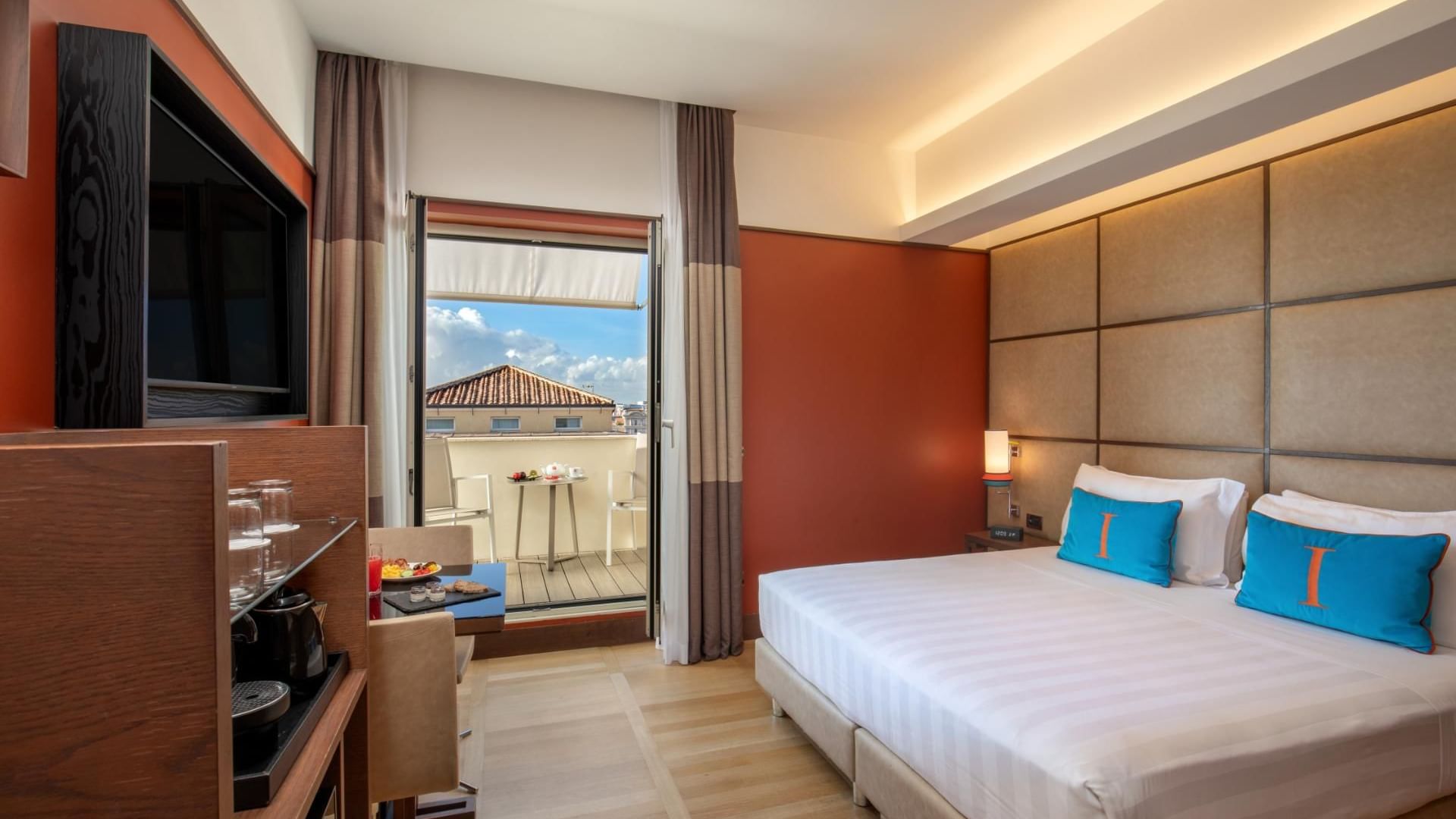 Stylish Superior Room with Balcony featuring a comfy bed, coffee area, and a city-view balcony at The Independent